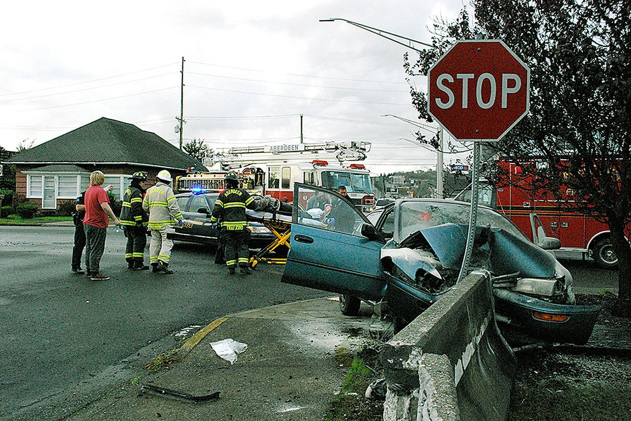 Police, Fire and EMS personnel respond to an accident at the intersection of Park and State streets early Friday evening. Three people were in the vehicle that T-boned a barrier at the stop sign. Two were transported to Grays Harbor Community Hospital for treatment. The extent of their injuries were unknown at time of press. (BOB KIRKPATRICK|THE DAILY WORLD)