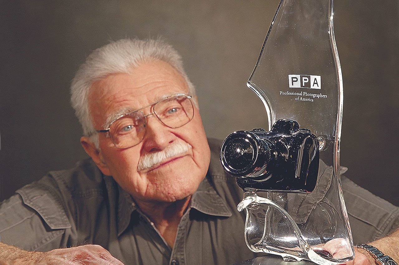 Ken Whitmire with his Lifetime Achievement Award from the Professional Photographers of America trophy. (Photo by Yakima Herald-Republic)