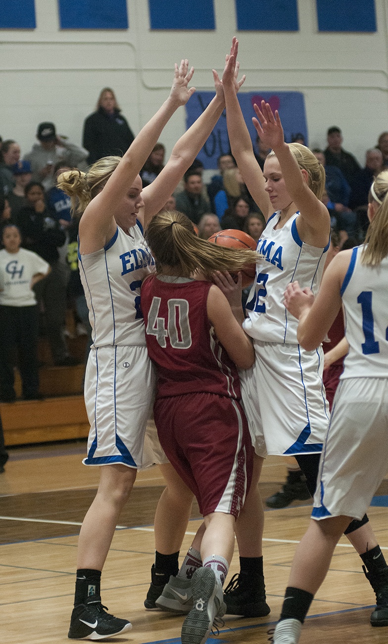 (Brendan Carl | The Daily World) Elma’s Molly Johnston, left, and Brooke Sutherby collapse on Hoquiam’s Kylee Bagwell during an Evergreen 1A League contest earlier this season.