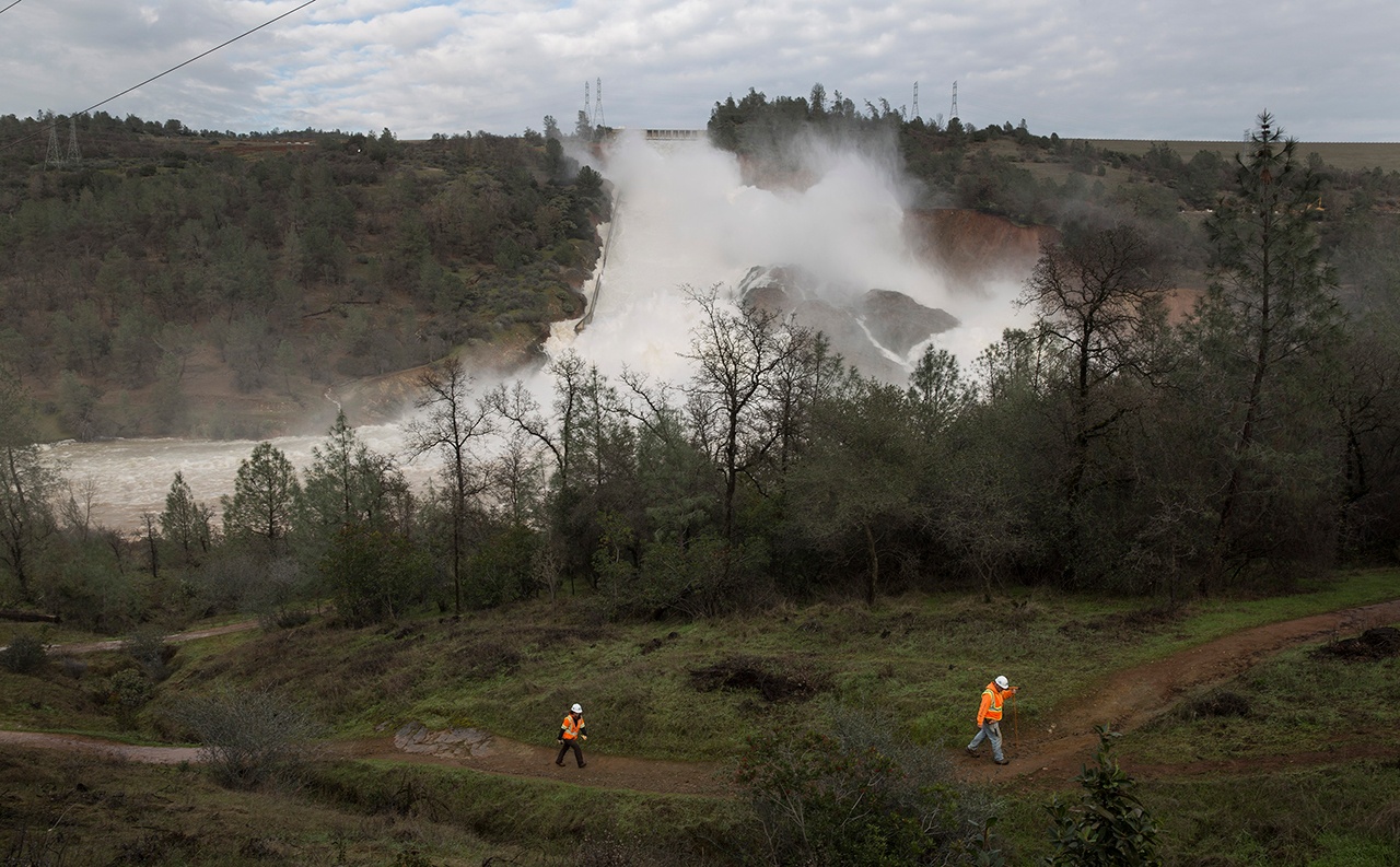 Pacific Gas & Electric crews work to move two electric transmission line towers before the Oroville Dam emergency spillway had to be used on Friday in Oroville, Calif. (Brian van der Brug/Los Angeles Times)