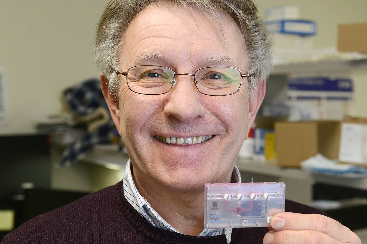 Dr. Lawrence Vernetti, research associate professor at the University of Pittsburgh’s Drug Discovery Institute, holds a one-chamber microfluidic device at the BioMedical Science Tower. (Nate Guidry/Pittsburgh Post-Gazette)