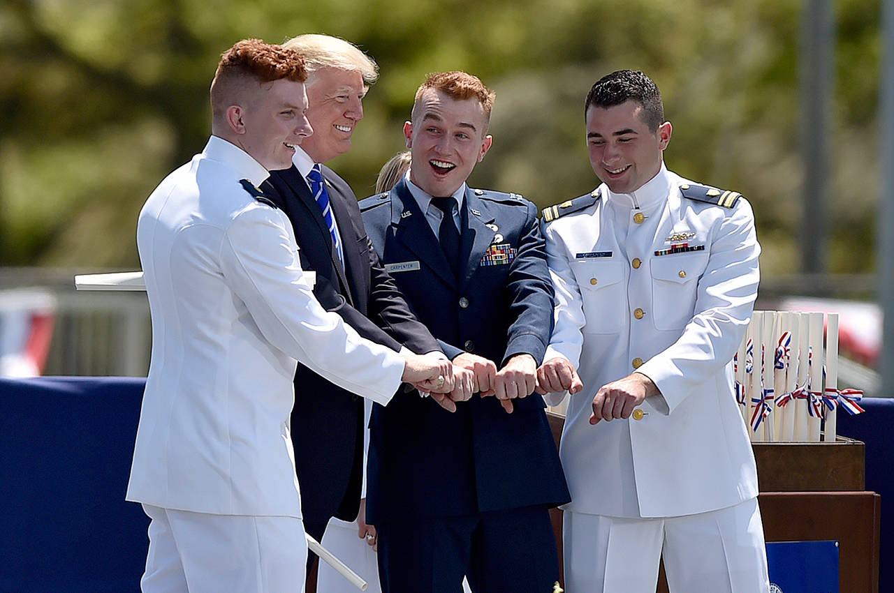 Ryan James Carpenter, left, of Aurora, Colorado, poses for a photograph with President Donald Trump and two others after Trump gave Carpenter his commission at the United States Coast Guard Academy’s 136th commencement exercises Wednesday, May 17, 2017 in New London, Conn. (Cloe Piosson/Hartford Courant/TNS)