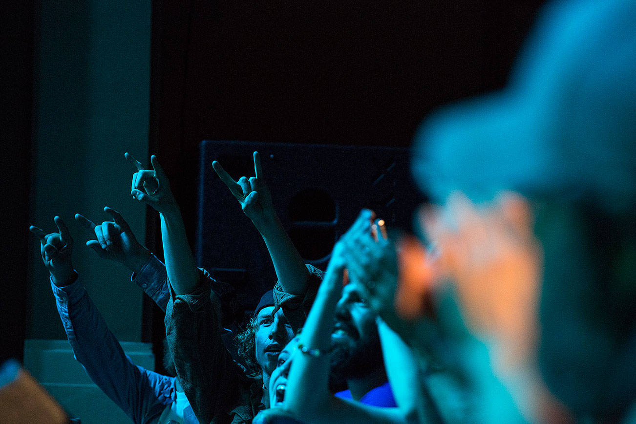 Audience members hold up horn hands for Leon Virgil Bowers as he and his band play at the D&R Theatre at the 2015 Kurt Cobain Days.