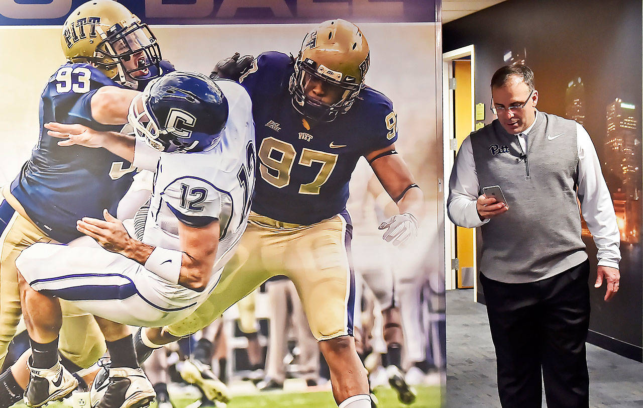 Pitt head coach Pat Narduzzi checks his phone during National Signing Day on Feb. 1, 2017 at the team’s facility. College football recruiting nowadays is much more than phones and fax machines. (Matt Freed/Post-Gazette)