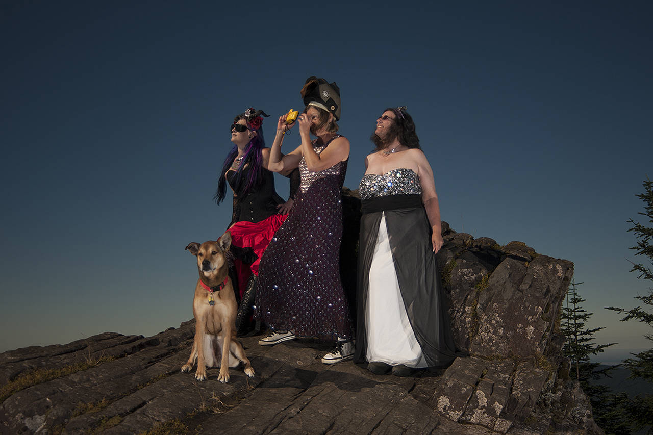 (Photo by Bob Merrill)                                From left: Erin Young, Marcy Merrill and Kat Bryant (with Rose, of course) enjoy the eclipse in style atop Radar Ridge, near Naselle.