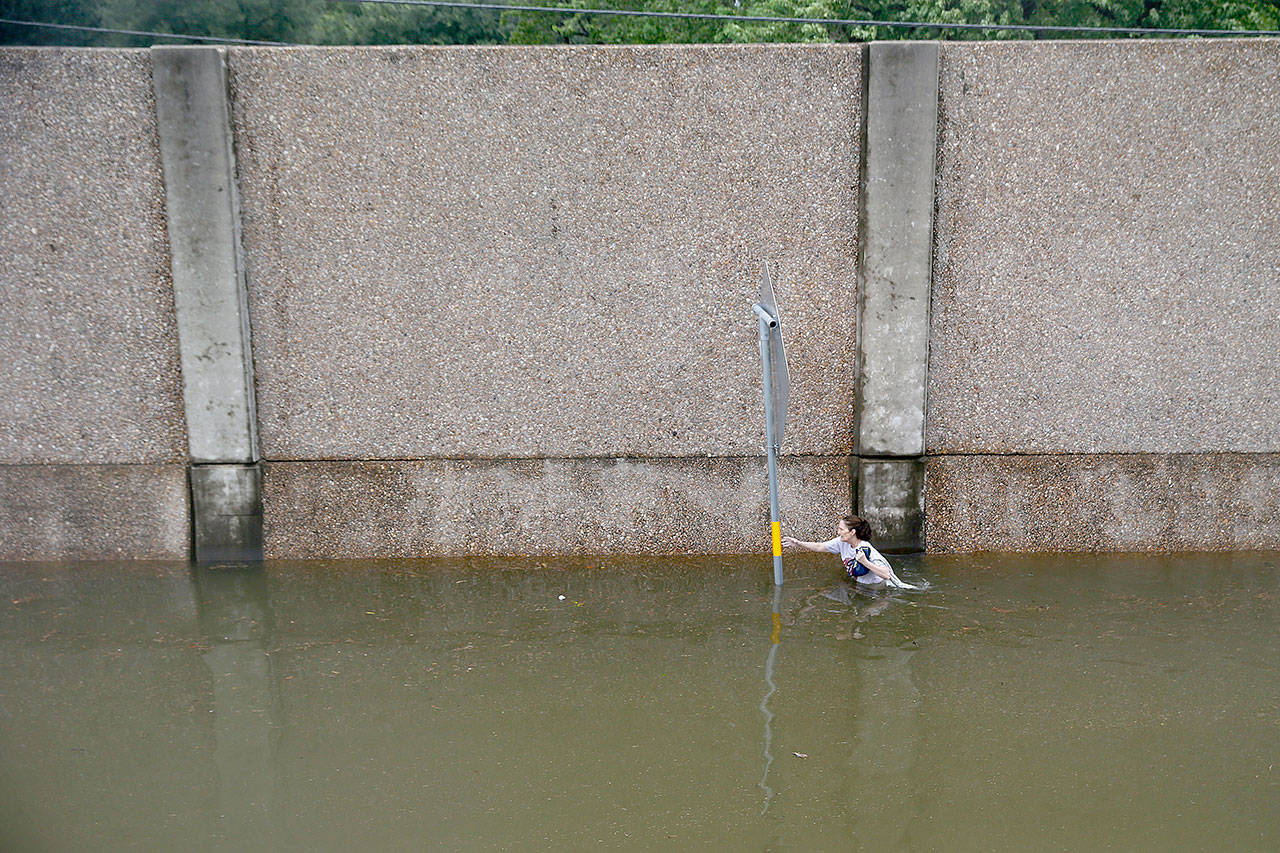 A woman struggles to wade through shoulder-deep water as she escapes from her Houston home on Sunday as Tropical Storm Harvey continues to cause major flooding throughout Southeast Texas. (Robert Gauthier/Los Angeles Times)