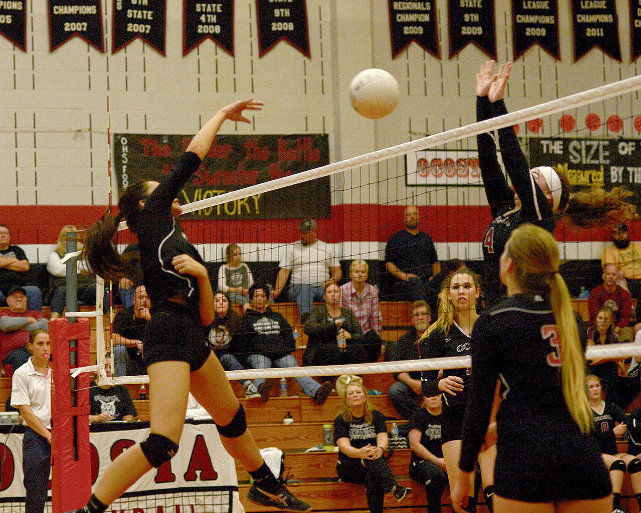 Photo by Bob Hitt — Raymond’s Tina Sypaphay, left, spikes against defensive pressure by Ocosta’s Kaylee Barnum on Monday night.