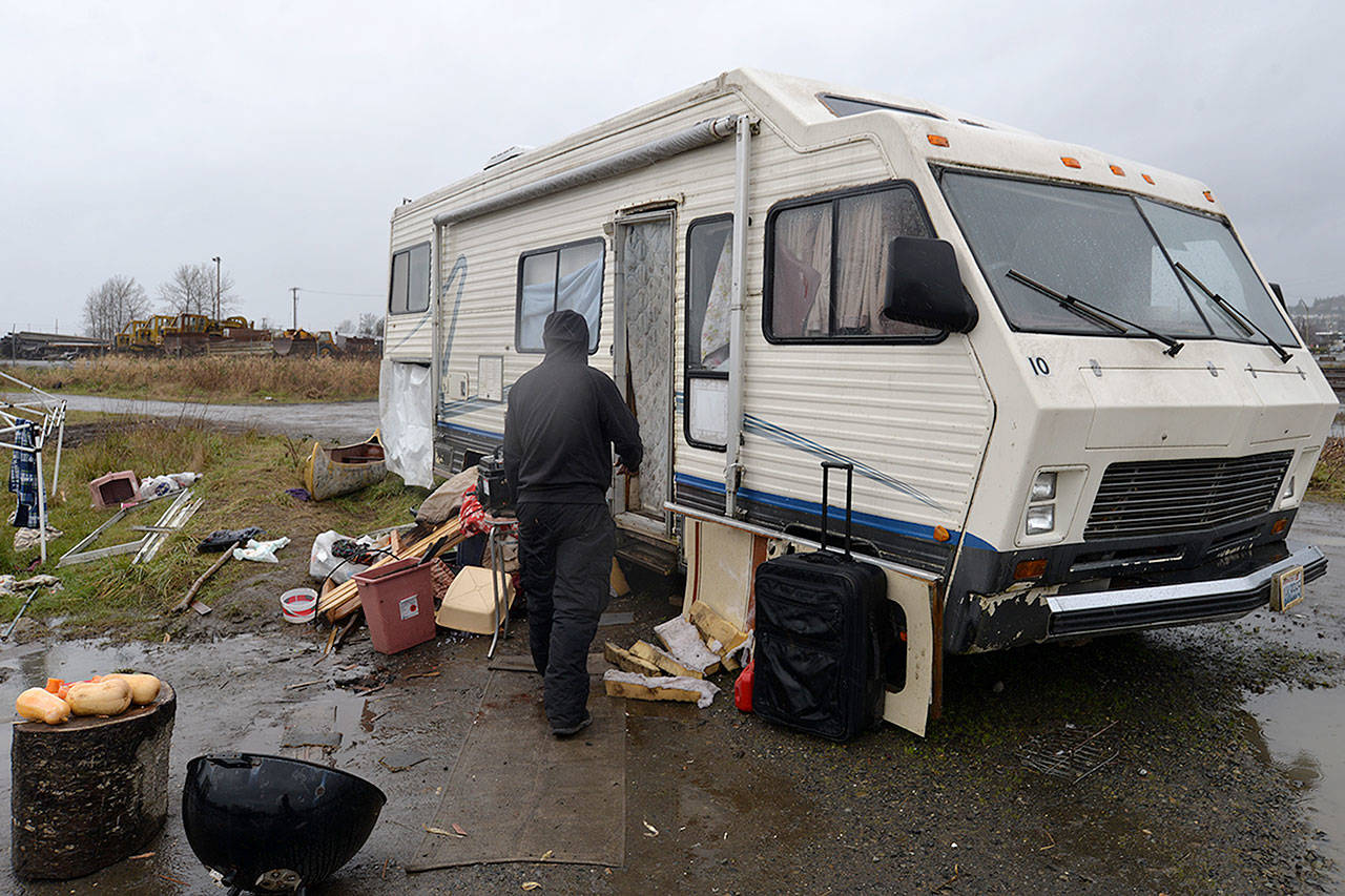 LOUIS KRAUSS | THE DAILY WORLD Brett Hussey visits a neighboring trailer home along the Wishkah River in Aberdeen. The trailer owners received city notices stating they must remove their vehicles.