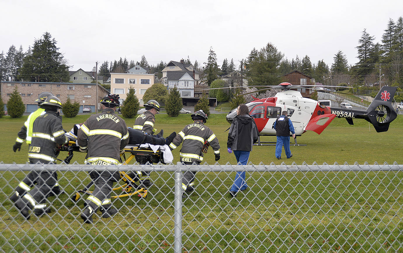 DAN HAMMOCK | THE DAILY WORLD                                Aberdeen Fire Department personnel meet a helicopter crew from Airlift Northwest as part of the Every 32 minutes program at Aberdeen High School. The helicopter landed in the soccer field adjacent to the high school parking lot and took a student who was playing a critically injured accident victim.