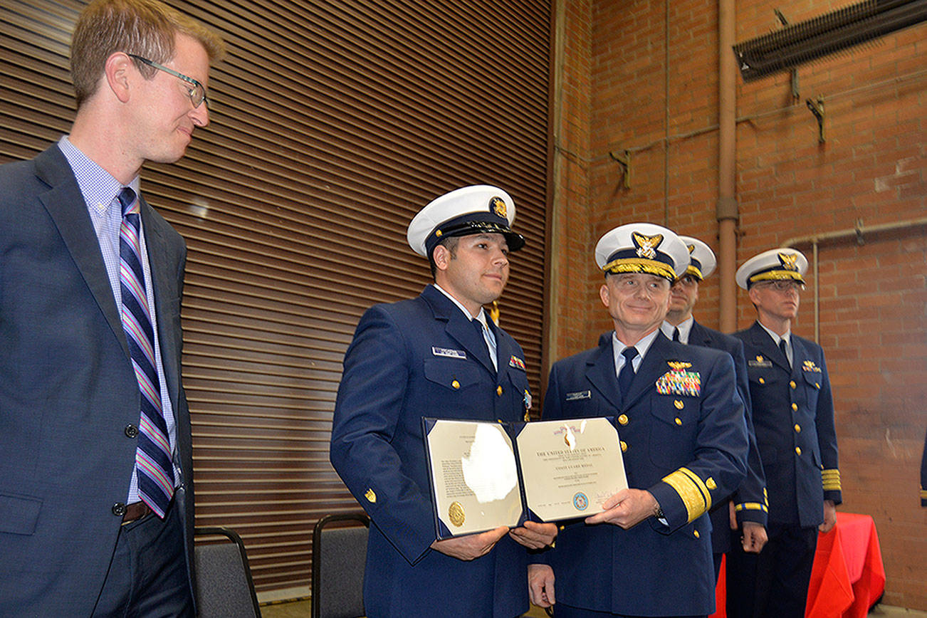 LOUIS KRAUSS | THE DAILY WORLD Coast Guard Officer Jacob Hylkema (second from left) receives a medal for heroism in Westport Friday afternoon, as U.S. Rep. Derek Kilmer watches. Hylkema volunteered to swim through 18 to 20-foot waves to rescue a drowning sailor one night in 2016.