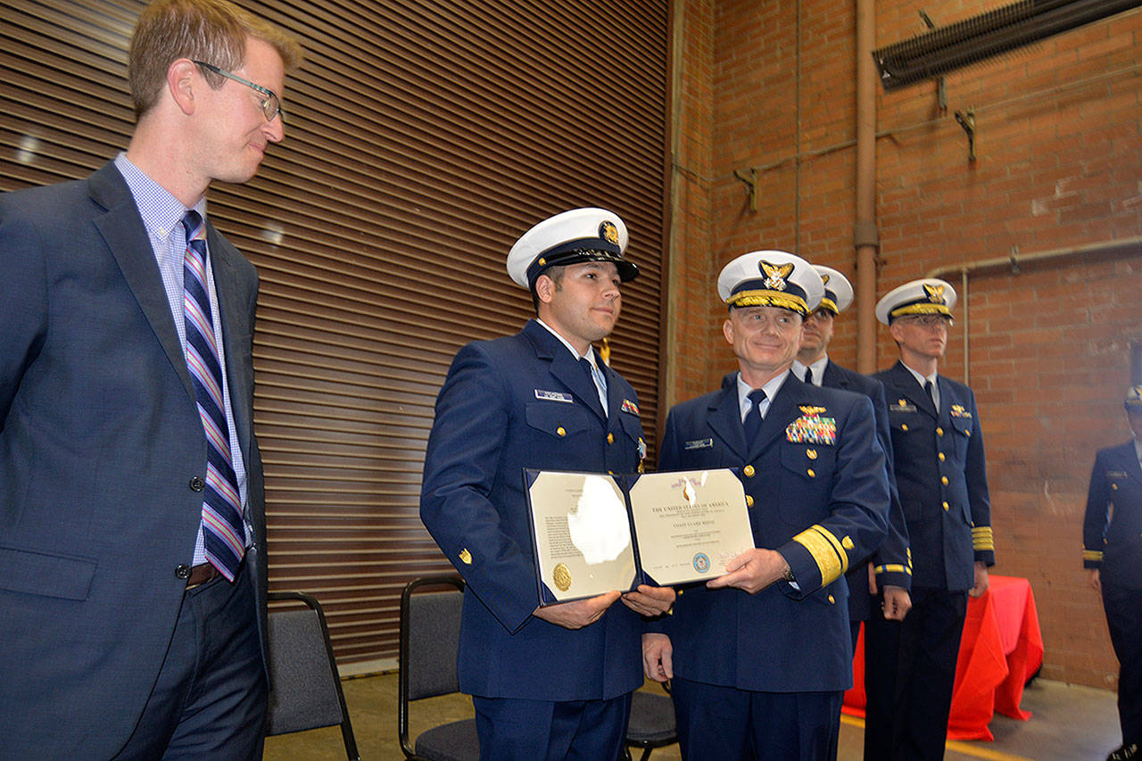 LOUIS KRAUSS | THE DAILY WORLD Coast Guard Officer Jacob Hylkema (second from left) receives a medal for heroism in Westport Friday afternoon, as U.S. Rep. Derek Kilmer watches. Hylkema volunteered to swim through 18 to 20-foot waves to rescue a drowning sailor one night in 2016.