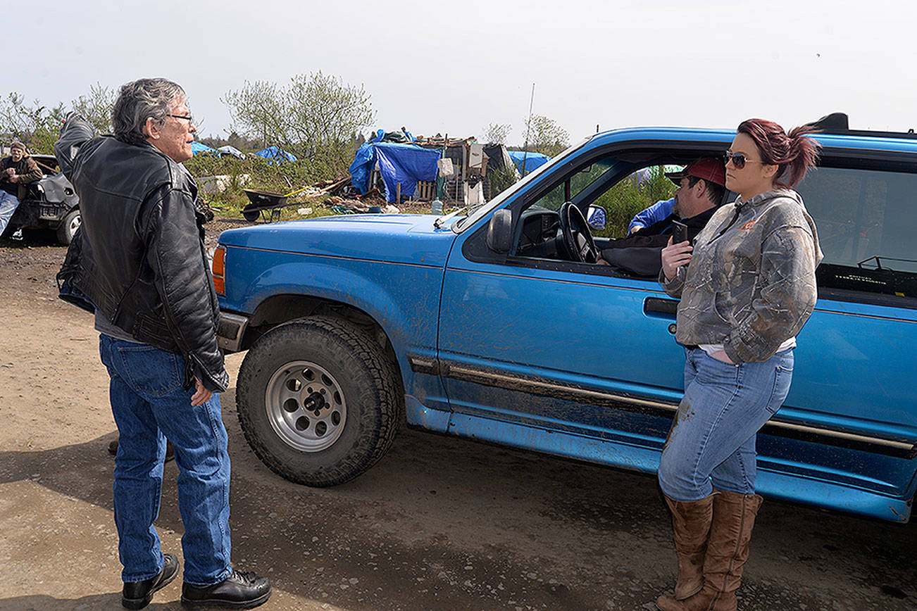 LOUIS KRAUSS | THE DAILY WORLD Charles Feick (left), who is President of Green Harvest Cannabis and is working with Sam Hutchinson to assist in finding homes and cleaning out the riverfront homeless camps in Aberdeen, speaks with Revival of Grays Harbor President Emily Reed.