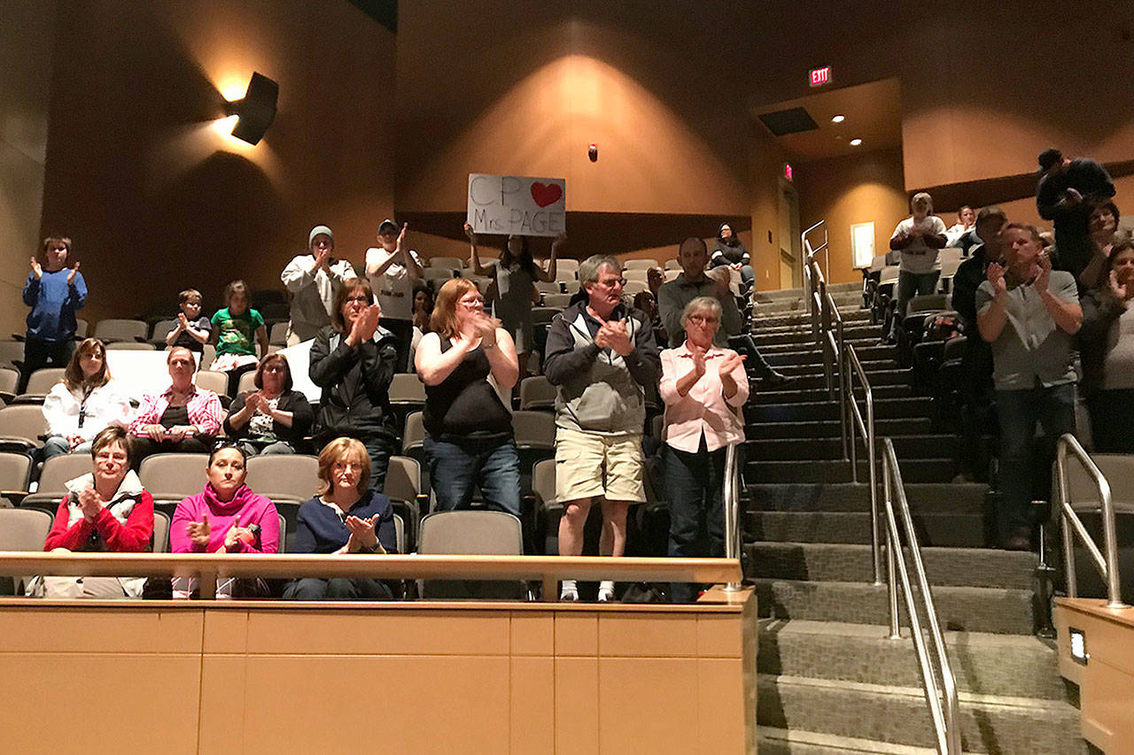 LOUIS KRAUSS | THE DAILY WORLD Audience members applaud someone speaking in support of Central Park Elementary Principal Barb Page, who was told she is being repositioned after this year.