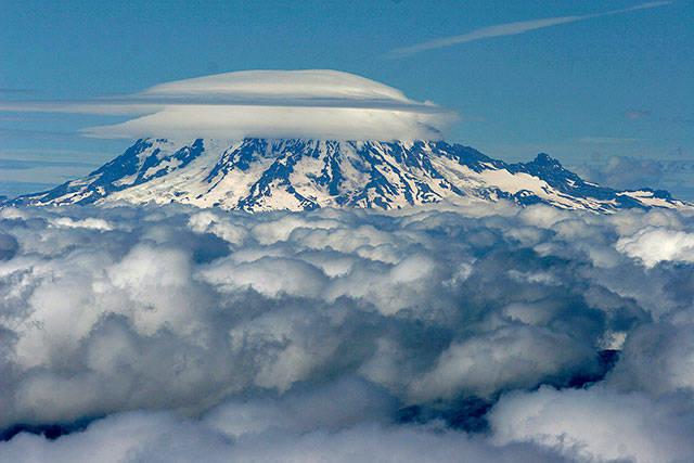 The summit of Mount Rainier, blanketed with cloud cover, as seen from the top of Mount St. Helens. (Steve Ringman/The Seattle Times)