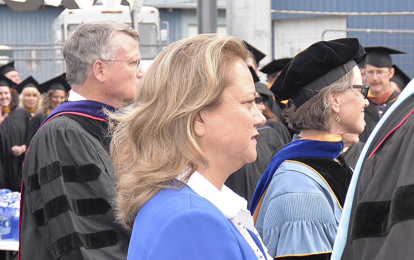 DAN HAMMOCK | THE DAILY WORLD                                Quinault Indian Nation president Fawn Sharp stands with Grays Harbor College educators watching nearly 200 students take to Stewart Field in Friday’s commencement ceremony. Sharp was the speaker, and is a member of the college board of trustees and herself is a 1988 graduate of the school.