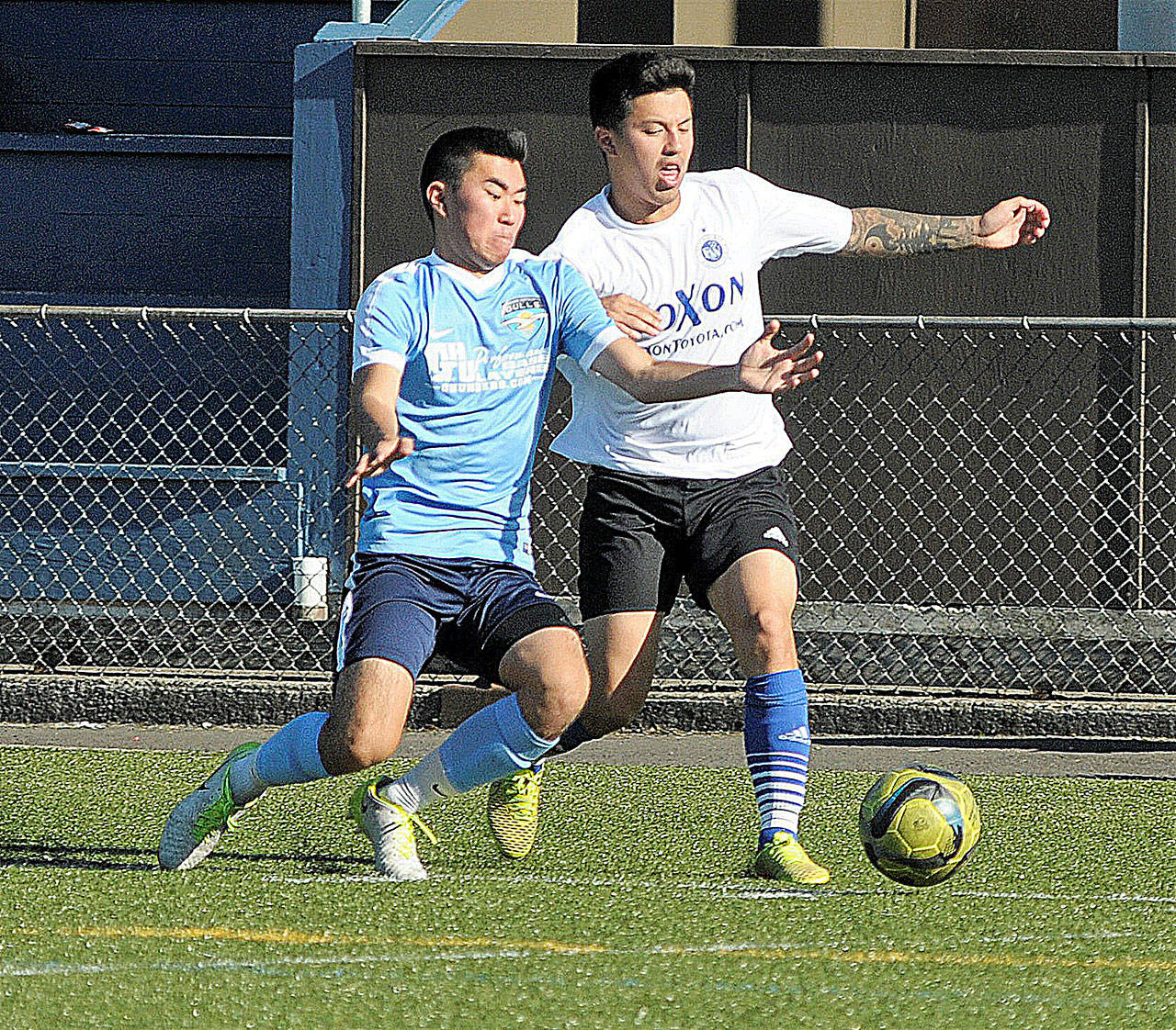 Gulls outside back Rick Hatate, left, attempts a tackle on a Federal Way Midfielder on June 23. Hatate joined the team mid-season and is one of approximately seven players Grays Harbor rotates on the backline. (Hasani Grayson | The Daily World)