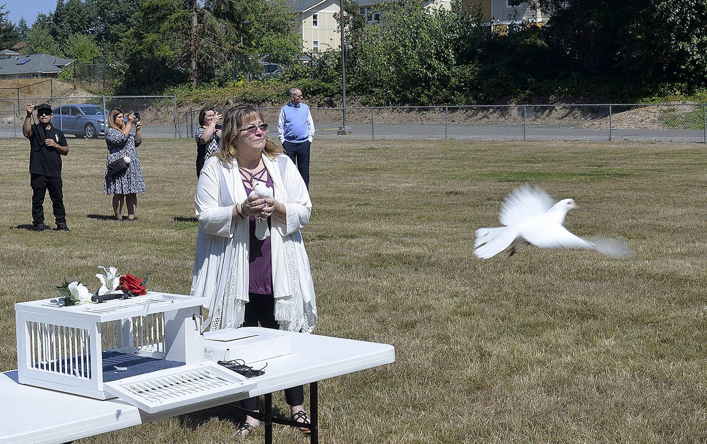 DAN HAMMOCK | THE DAILY WORLD                                Melissa Baum holds a dove as others are released skyward following her daughter’s memorial service Saturday in Olympia.