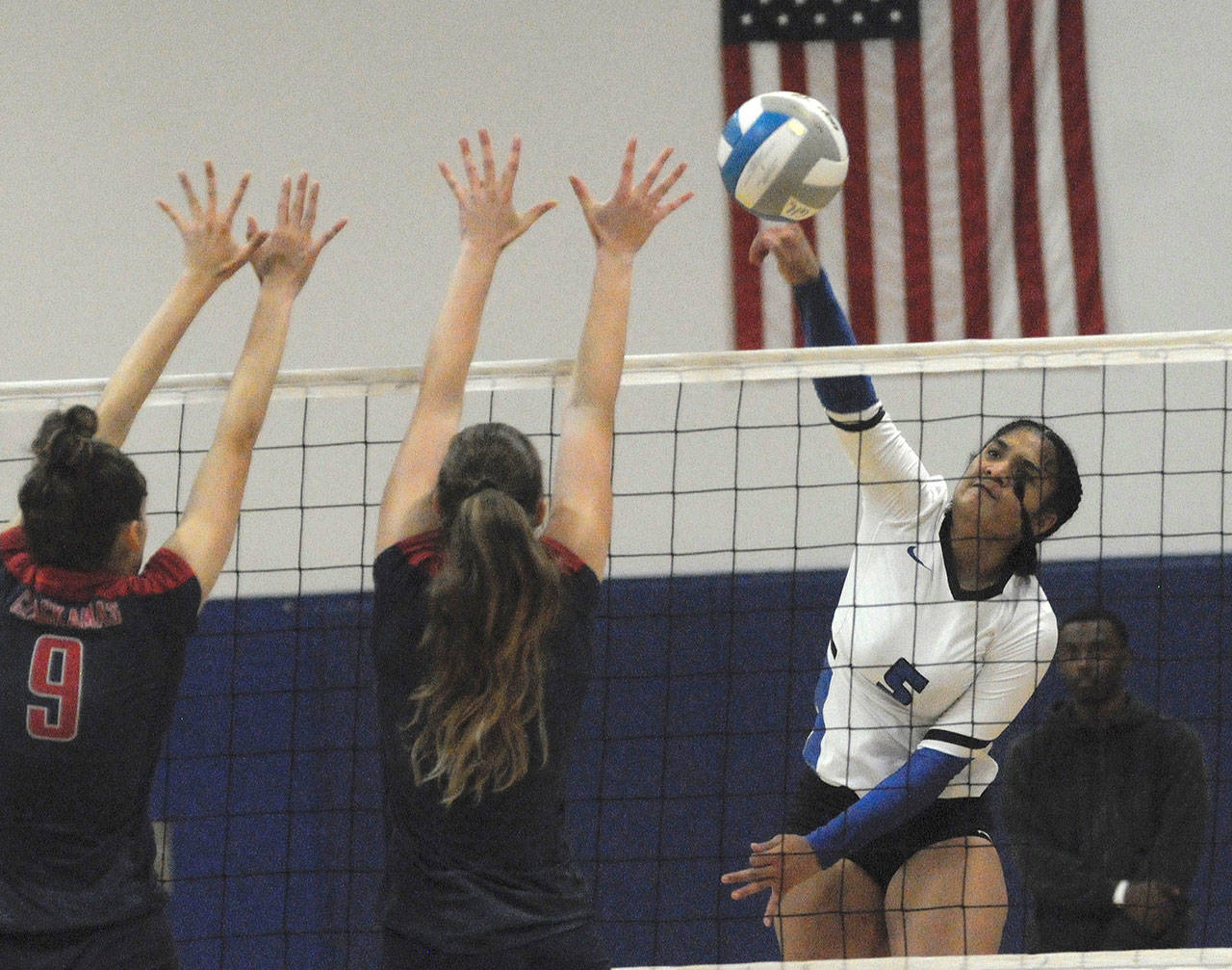 Grays Harbor’s Leleo Maeva, right, puts her shot past a Clackamas block attempt in a match on Monday night in Aberdeen. The Chokers won the match 3-0. (Hasani Grayson | The Daily World)