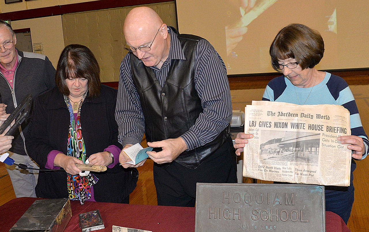 DAN HAMMOCK | GRAYS HARBOR NEWS GROUP                                Members of the Hoquiam High School Class of 1969 open a time capsule Friday that was placed behind the cornerstone of the student center, where it had been since the school was dedicated exactly 50 years ago to the day. At left is Denise Burke, at center is former Hoquiam City Councilman John Pellegrini.