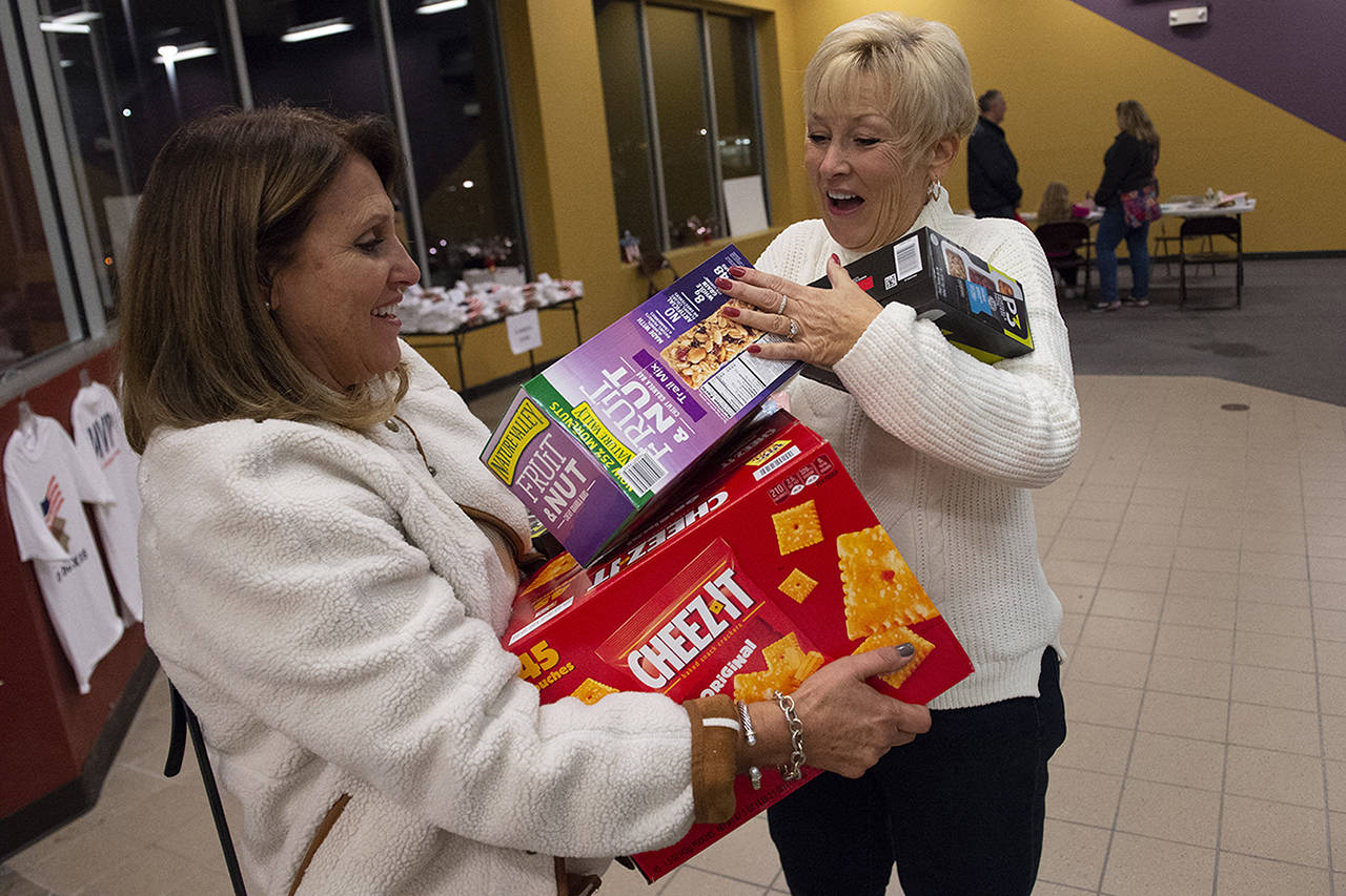 Patrick Raycraft | Hartford Courant                                 Karen Cote, right, welcomes Donna Bordonaro’s donation of food items to Hero Boxes.