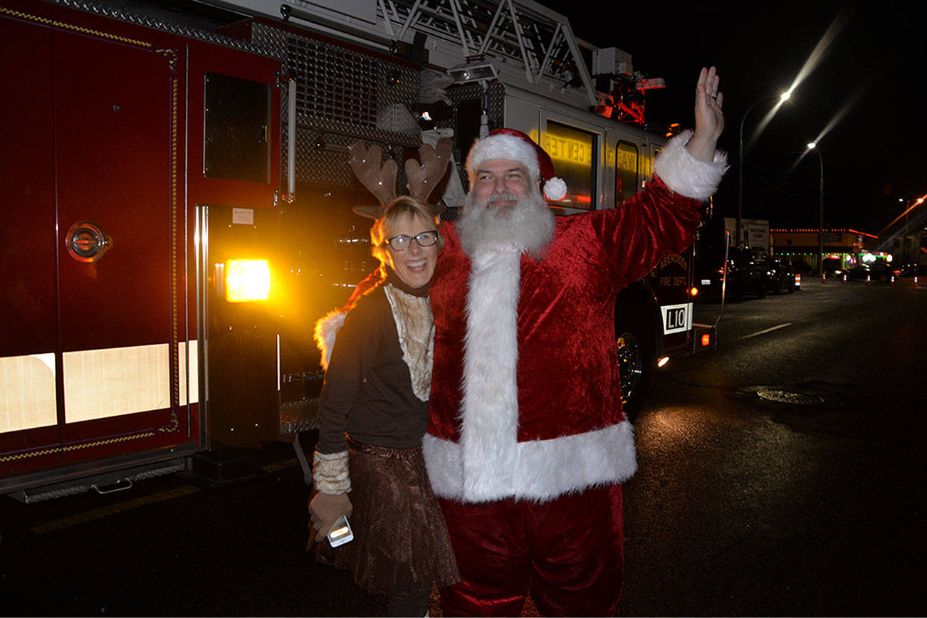 (Louis Krauss | Grays Harbor News Group)                                Santa poses with Bette Worth after emerging from a firetruck.