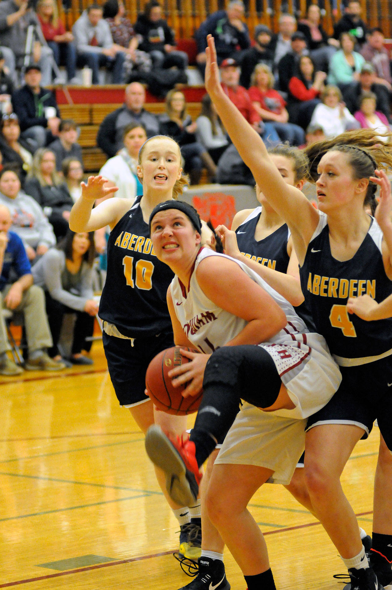 Hoquiam junior Maddie German grabs an offensive rebound against a trio of Aberdeen Bobcats during the Grizzlies’ 48-38 rivalry-game victory on Thursday. (Ryan Sparks | Grays Harbor News Group)