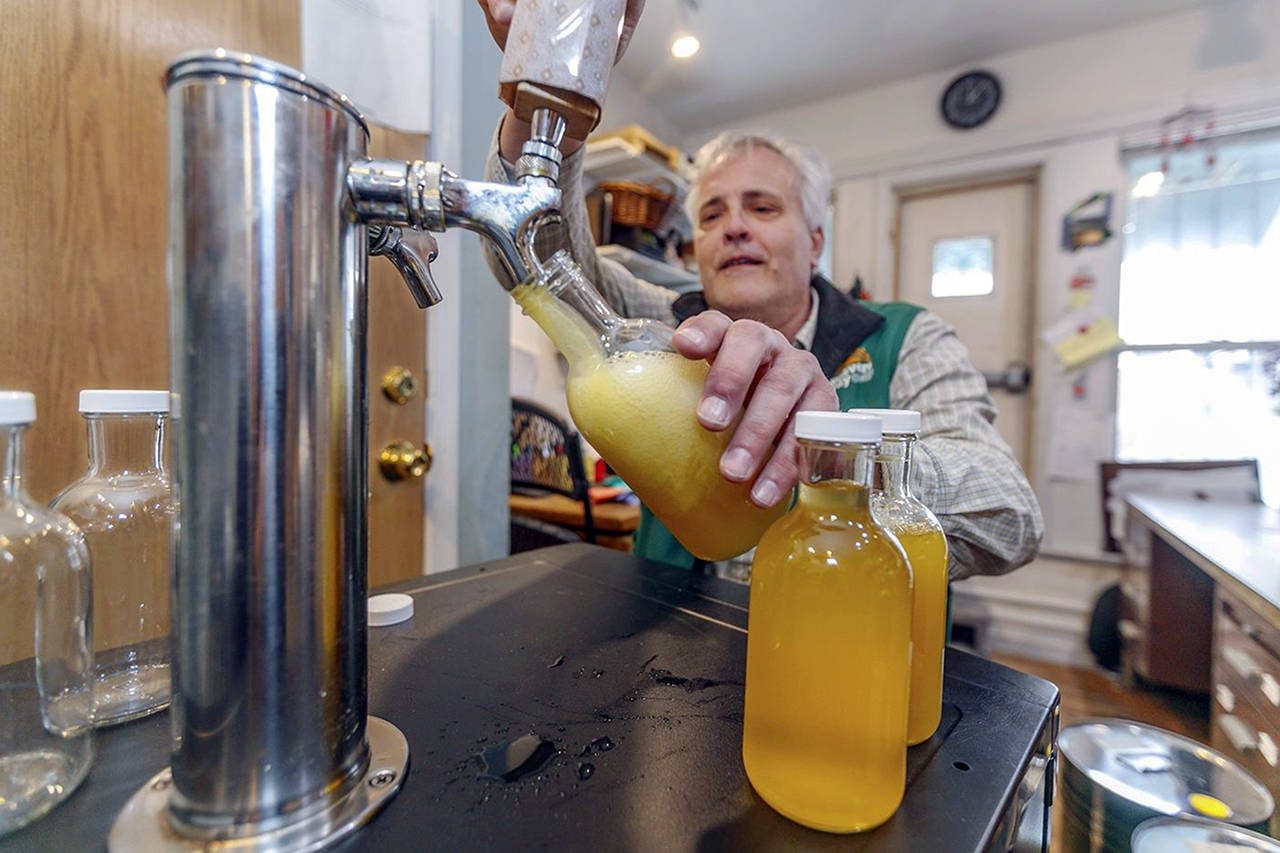 Weavers Way Co-op store manager Rick Spalek fills 16-ounce bottles with GT’S Cannabliss kombucha, which contains CBD. (Michael Bryant | The Philadelphia Inquirer)