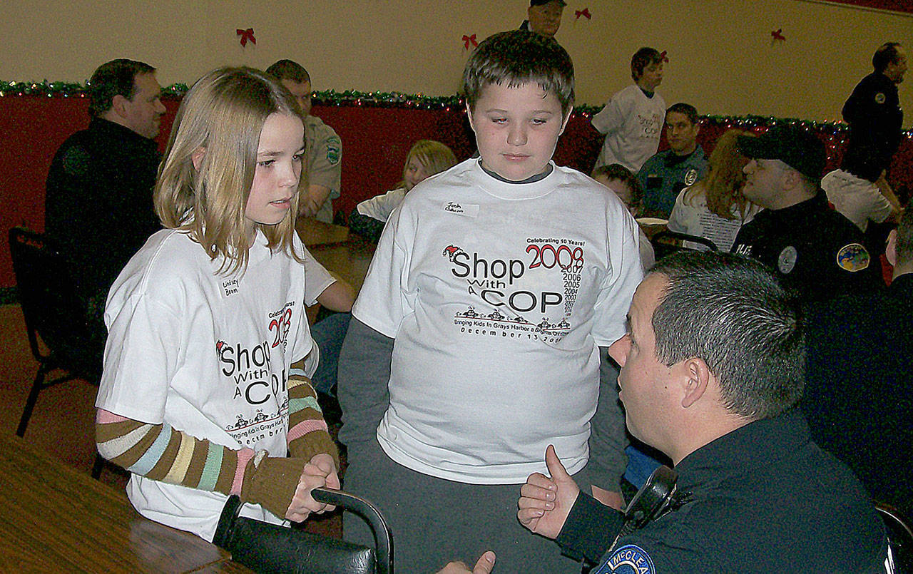 COURTESY LANE YOUMANS                                Lindsey Baum and her brother, Josh, speak with then McCleary Police officer John Graham at the Shop with a Cop event in December 2008. A little more than 6 months later she disappeared blocks from her home in McCleary.