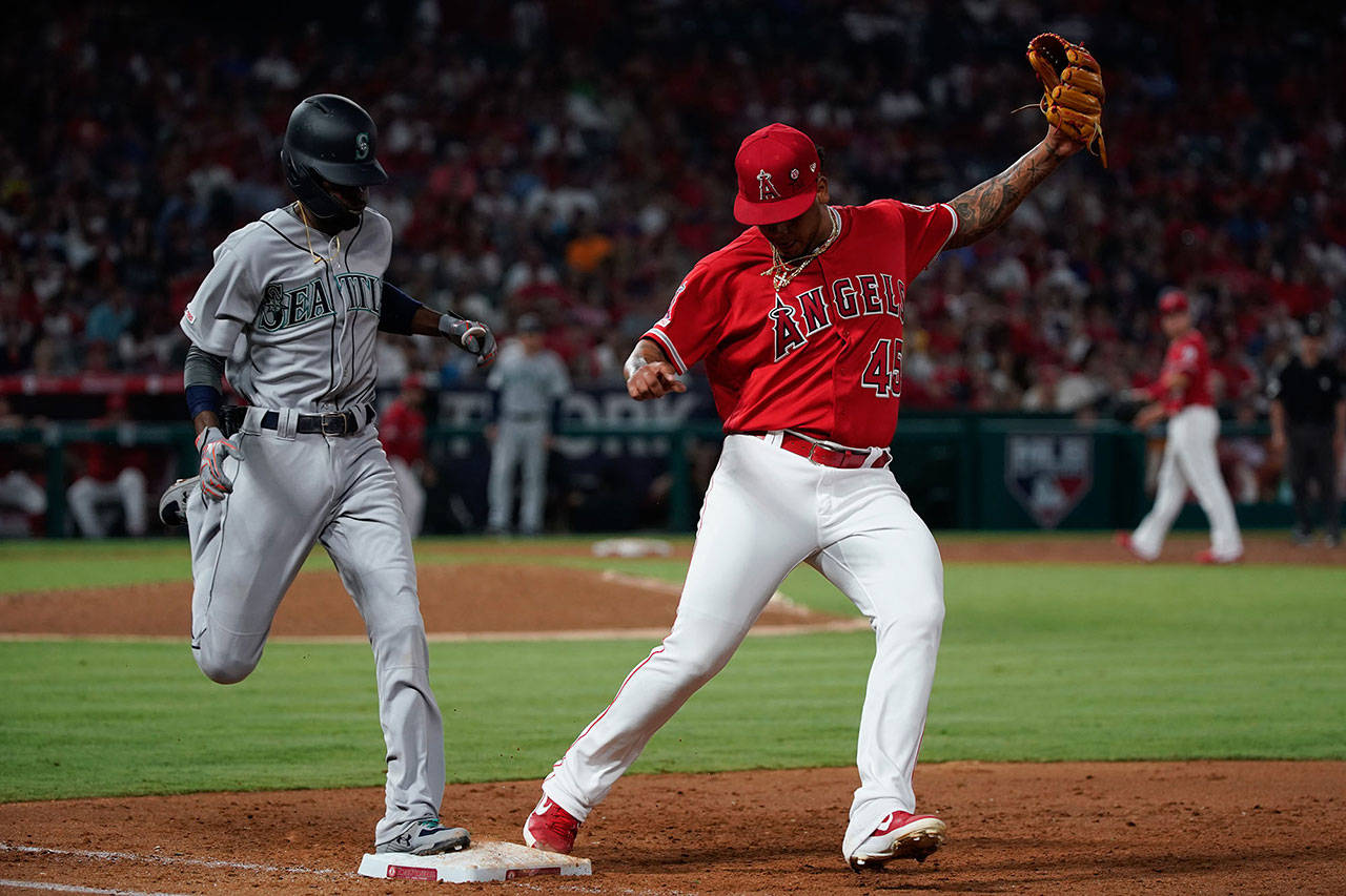 The Seattle Mariners’ Dee Gordon, left, is forced out at first base by Los Angeles Angels pitcher Felix Pena in the third inning at Angel Stadium in Anaheim, Calif., on Friday, July 12, 2019. (Kent Nishimura/Los Angeles Times/TNS)