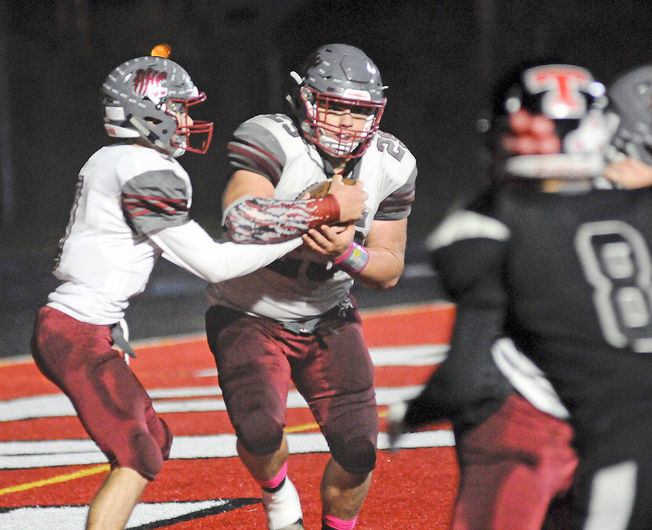 Hoquiam quarterback Dane McMillan, left, hands the ball off to running back Matt Brown during the Grizzlies’ 62-0 win over the Beavers on Friday. Hoquiam hosts county-rival Elma in a critical league contest at 7 p.m. on Friday. (Hasani Grayson | Grays Harbor News Group)