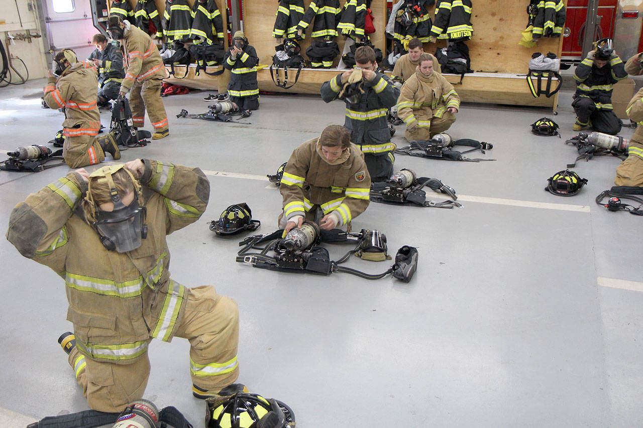 Montesano High School senior Alexandria Casey (front left) and other Monte and Aberdeen students don bunker gear Thursday, Oct. 10, 2019, at the Montesano Fire Station. Casey, who is Company C leader, and the others were taking part in a class on fire science offered through the schools by Fire Chief Corey Rux. (Michael Lang | Grays Harbor News Group)