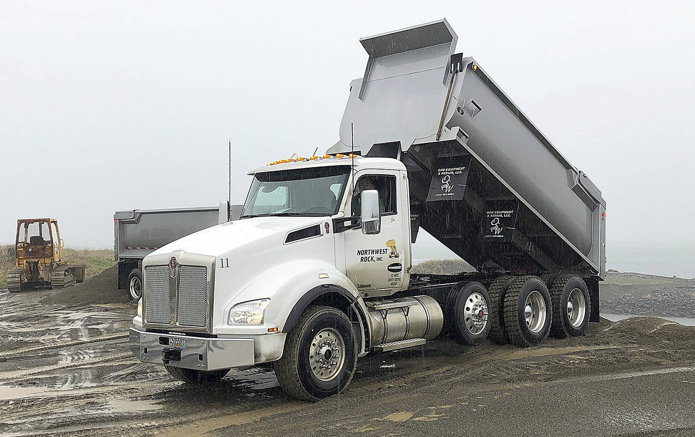 Photos COURTESY ARMY CORPS OF ENGINEERS                                Trucks from Northwest Rock Inc. are dumping sand on the breach fill area of Westport’s south jetty. Crews are about halfway through a project to shore up the spit between the jetty and the mainland.