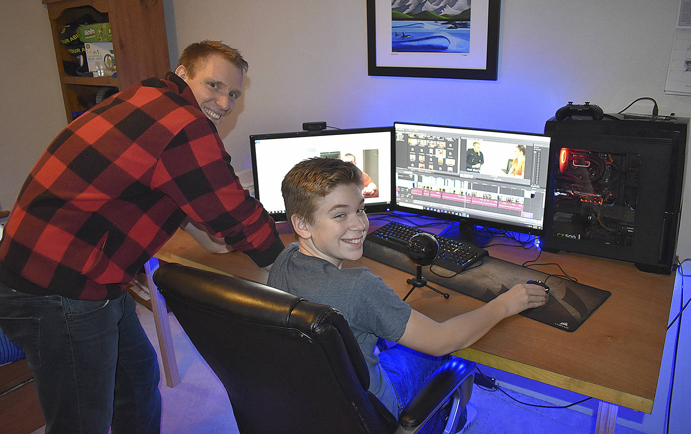 DAN HAMMOCK | GRAYS HARBOR NEWS GROUP                                 Aberdeen Police Officer Loren Neil and his 14-year-old son, Aiden, at the computer where the two spent countless hours producing a video.