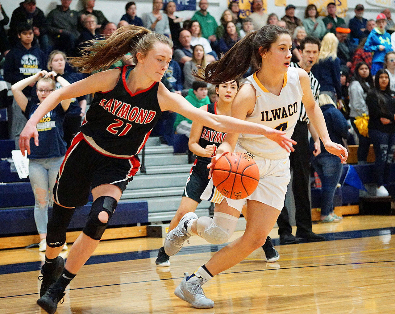 Raymond’s Kyra Gardner (21) goes for a steal against Ilwaco’s Erika Glenn during Friday’s battle for first place in the Pacific League at Ilwaco High School. Ilwaco won 46-32. (Photo by Rob Hilson)