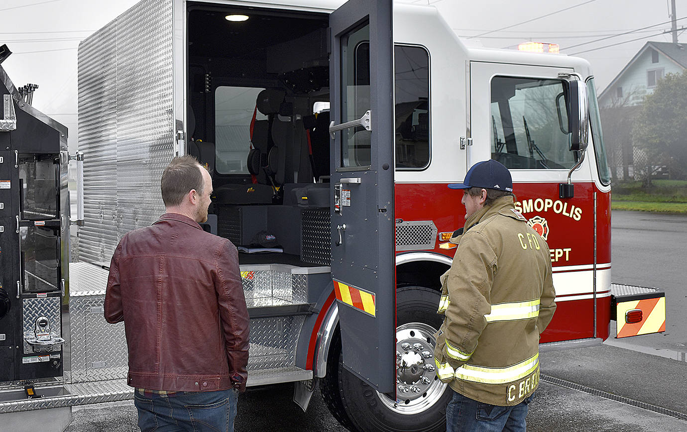 DAN HAMMOCK | GRAYS HARBOR NEWS GROUP                                 Cosmopolis Mayor Kyle Pauley, left, and Fire Chief Cody Bridges check out the interior of Cosi’s new fire engine.