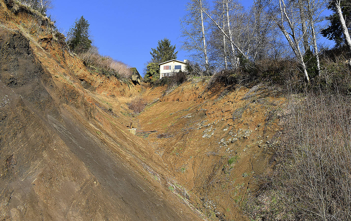 DAN HAMMOCK | GRAYS HARBOR NEWS GROUP                                 Demolition of the house at 432 Beacon Hill Drive in Hoquiam, hanging precariously over the slide that rendered it uninhabitable in January 2015, begins today.