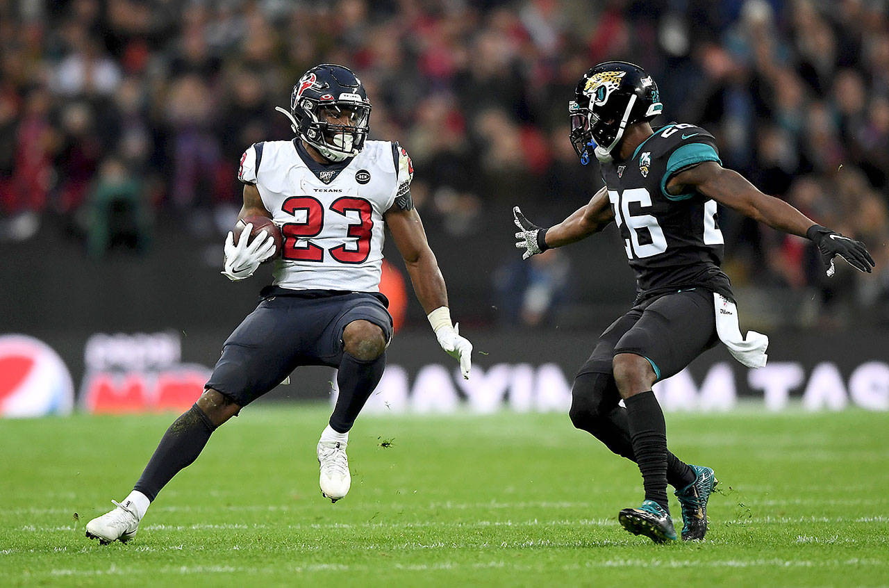 Carlos Hyde, formerly of the Houston Texans, gets past Jarrod Wilson of the Jacksonville Jaguars at Wembley Stadium on Sunday, Nov. 3, 2019 in London, England. (Alex Davidson/Getty Images)