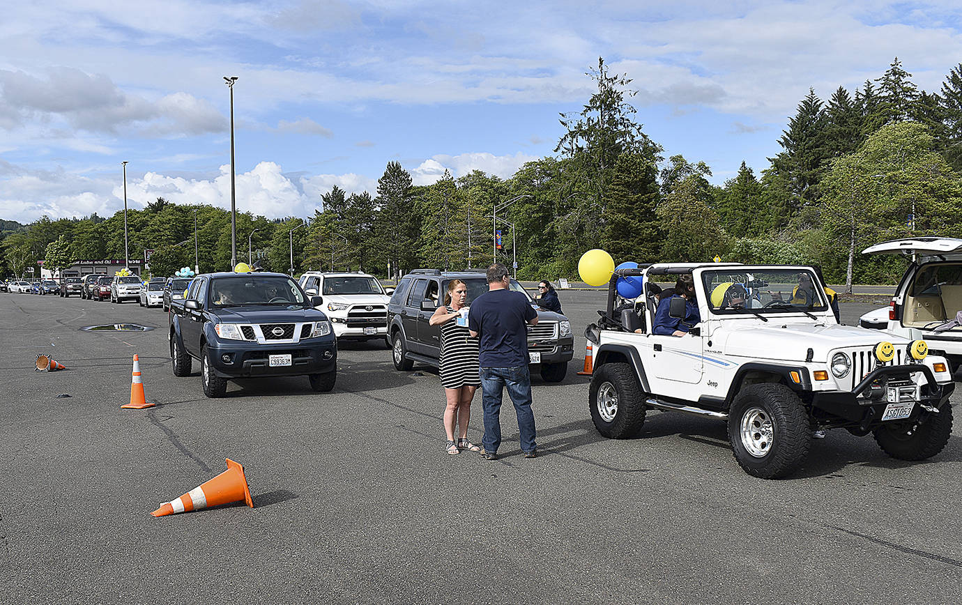 Photos by DAN HAMMOCK | GRAYS HARBOR NEWS GROUP                                More than 200 cars participated in the Aberdeen High School graduation parade Friday. Here cars are assigned numbers for the trek from Shoppes at Riverside to Stewart Field.