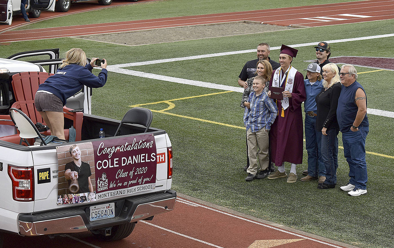 DAN HAMMOCK | GRAYS HARBOR NEWS GROUP                                 After getting their diplomas, Montesano High School graduates posed for photos with their families, who lined the track at Jack Rottle Field in their vehicles during the ceremony.