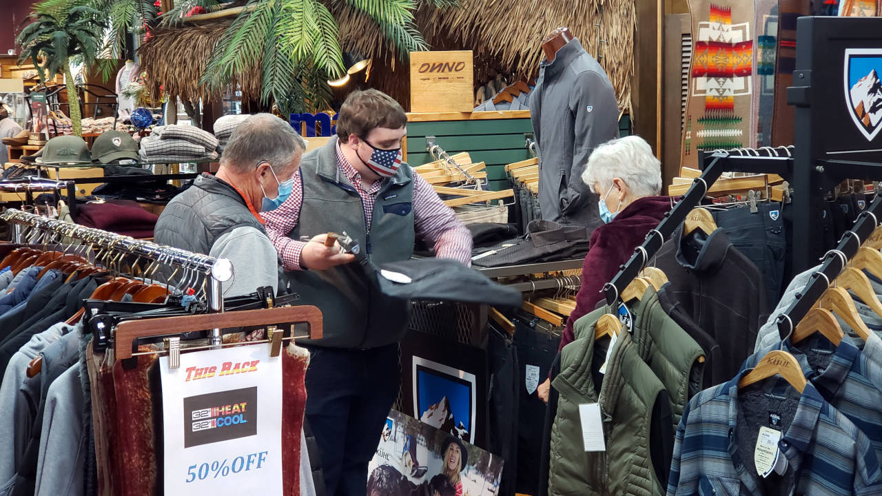 Waugh's Men's Store owner Daniel Crocker, middle, helps customers on Thursday in Aberdeen. (Ryan Sparks | The Daily World)