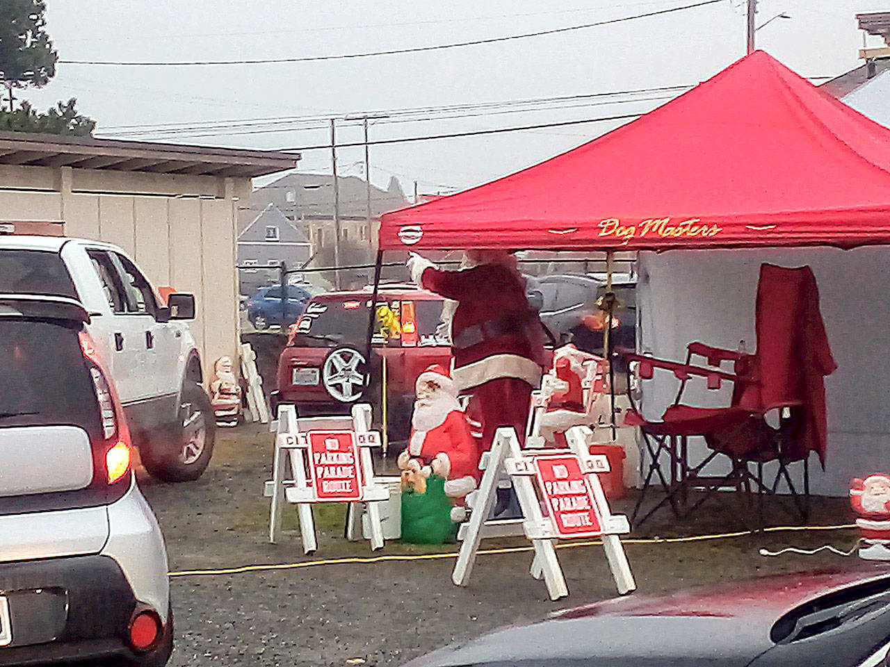 Santa Claus waves to children in slowly passing cars during the drive-through visit hosted by the Hoquiam Elks in their back parking lot last Saturday. (Photos by David Haerle)