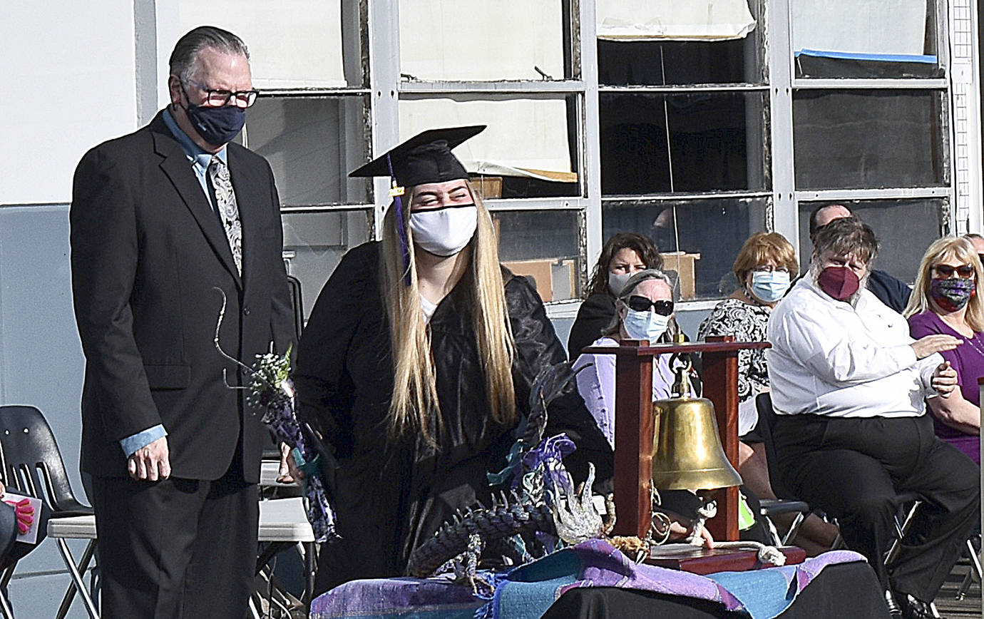 DAN HAMMOCK | THE DAILY WORLD 
Makayla Renee Dollarhyde rings the traditional bell after receiving her diploma from Harbor High School Principal David Glasier on Tuesday.