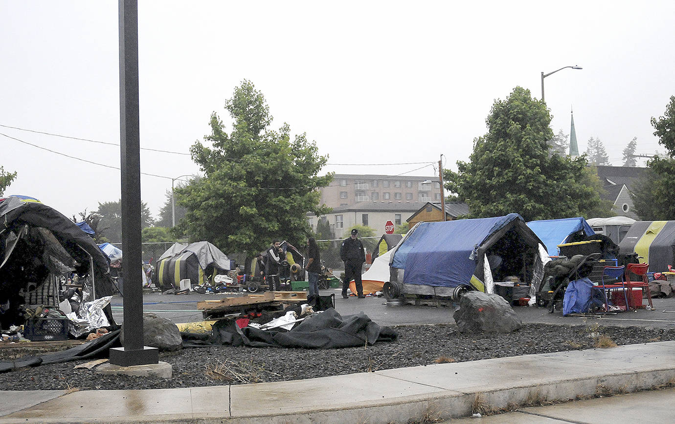 DAVE HAVILAND | THE DAILY WORLD 
Remaining Aberdeen TASL residents gather their belongings as the fence surround the city-run homeless camp is taken down Friday morning. The city closed the camp Friday at noon.