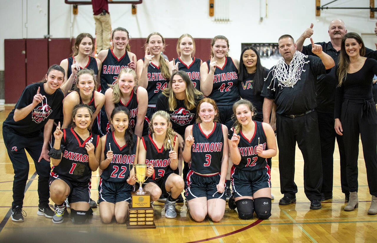 PHOTO BY KEVIN MILLER The Raymond Seagulls pose with their championship trophy after defeating Chief Leschi 68-60 in the 2B District 4 title game on Saturday at WF West High School in Chehalis.