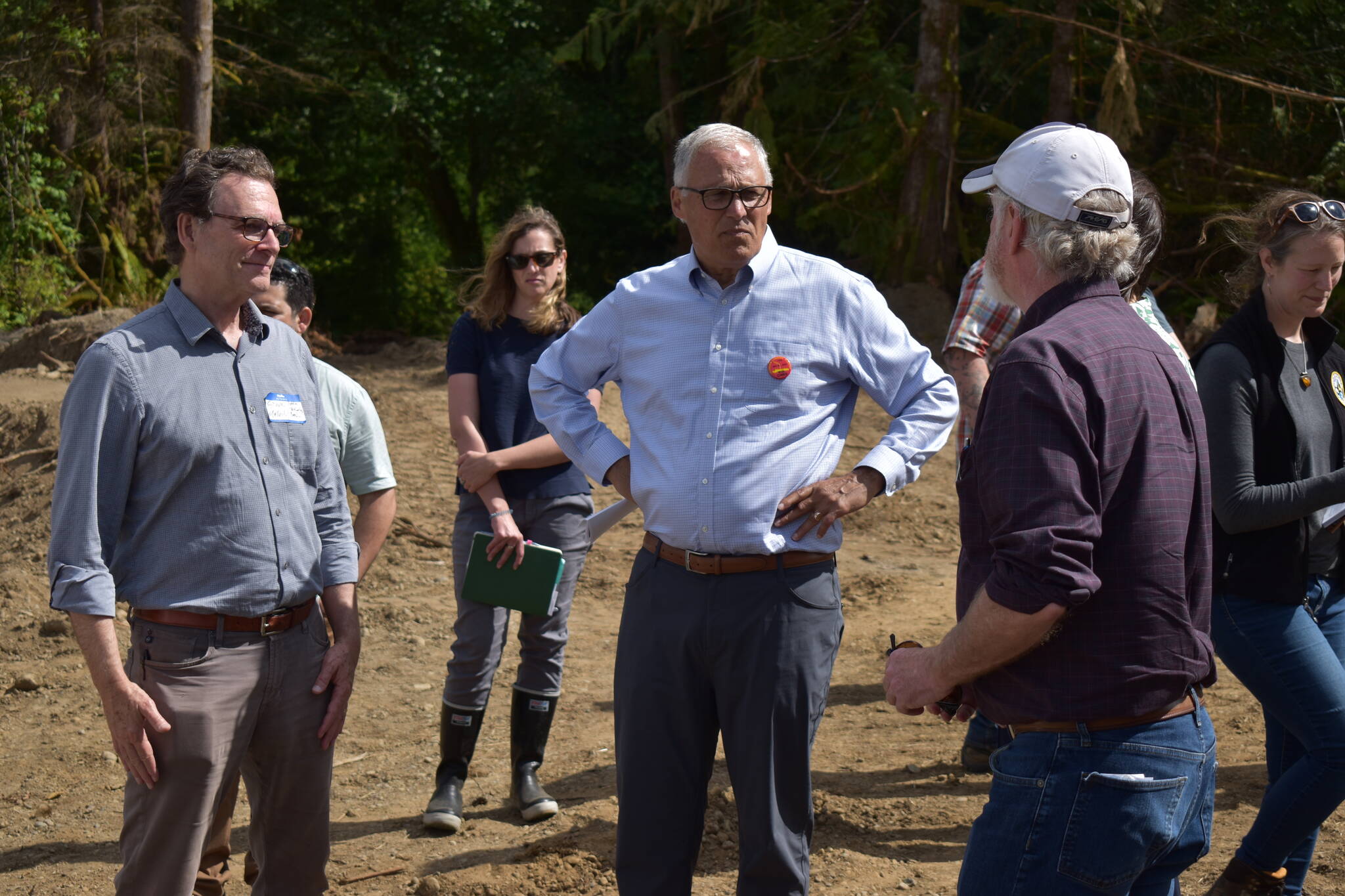 Gov. Jay Inslee (center) stands around board members from the Office of Chehalis Basis on July 7, 2022, as they describe the work being done for the Wynoochee River restoration as part of the Early Action Reach projects. The Wynoochee River restoration project, which started in 2021, is slated for completion by the end of the summer. (Allen Leister | The Daily World)