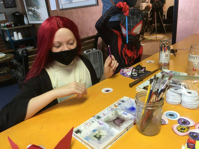 A participant paints eyeballs for pumpkins at the Cosi Art Center.