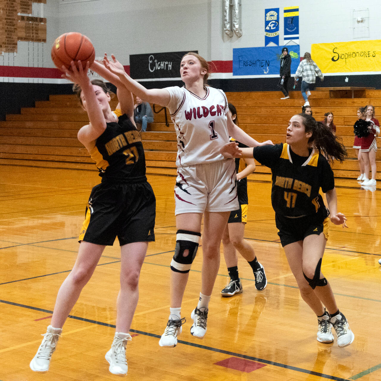 PHOTO BY VAN ADAM DAVIS Ocosta’s Alexandria Matthews (1) competes for a rebound against North Beach’s Kayla Easman (41) and Malia Cox during the Wildcats’ 36-29 win on Wednesday in Westport.