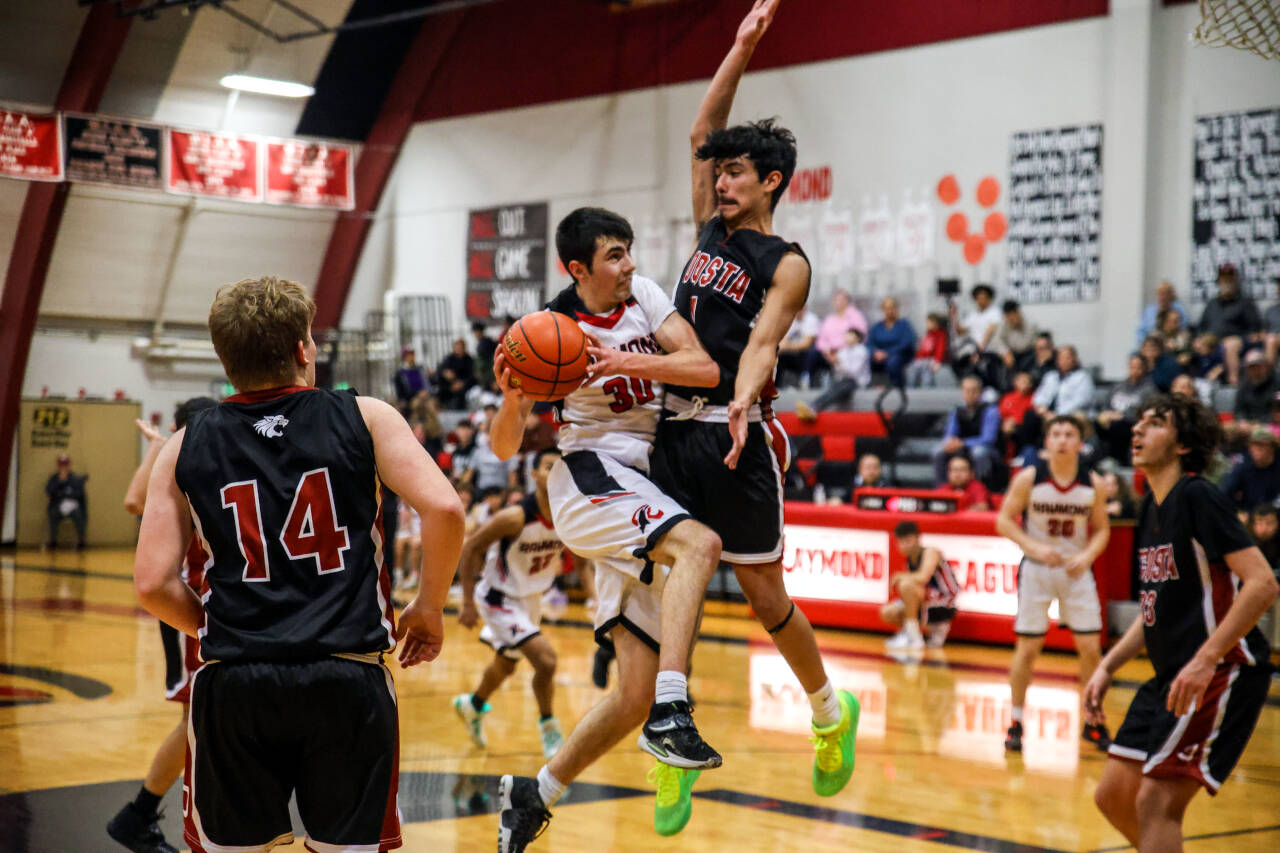 PHOTO BY LARRY BALE Raymond’s Morgan Anderson (32) drives to the basket while defended by Ocosta’s Josh Figueroa during the Wildcats’ 72-50 win on Friday at Raymond High School.