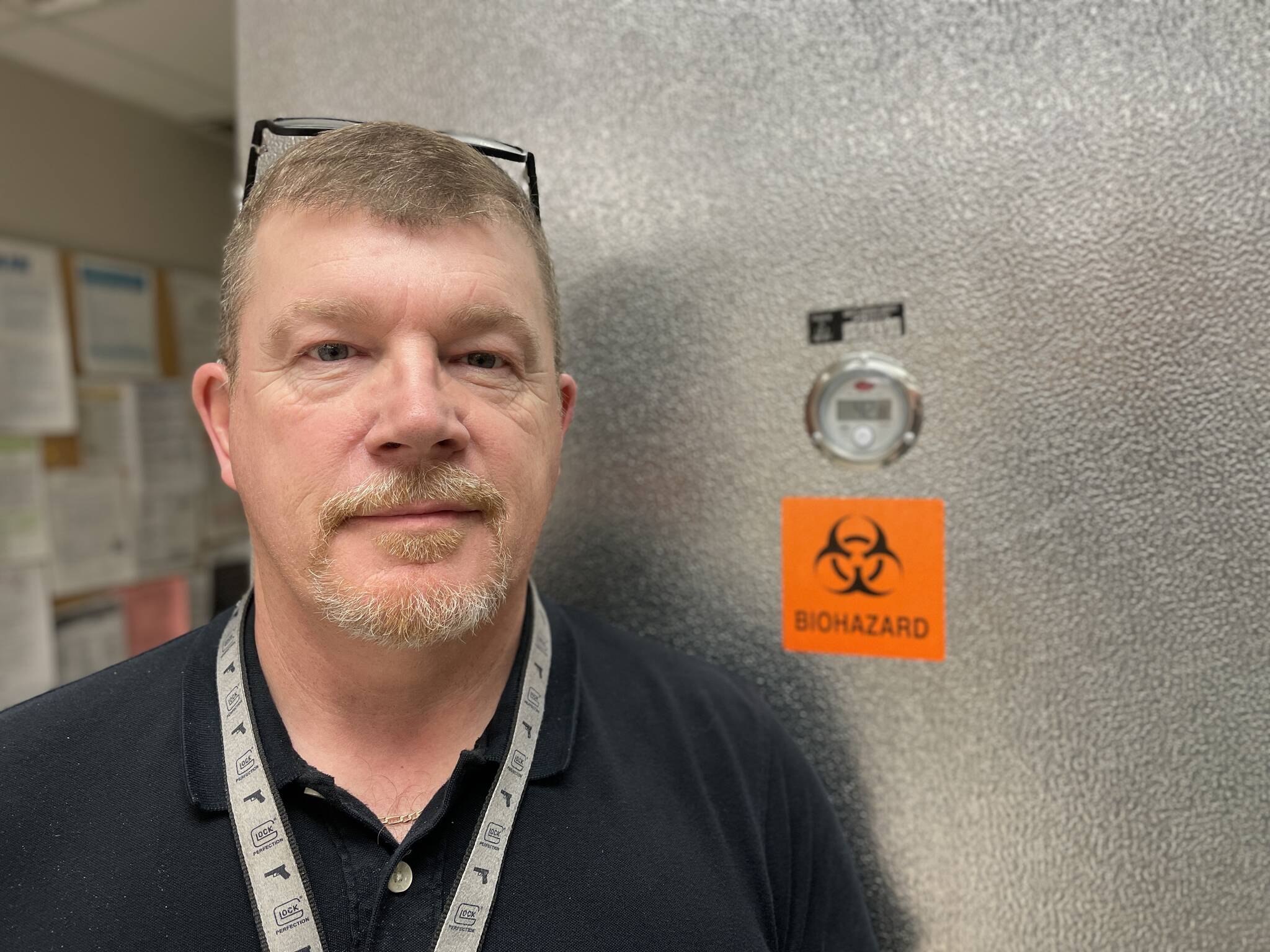 Grays Harbor County Coroner George Kelley, recently started in the position, stands in front of the office’s fridge on Feb. 8. (Michael S. Lockett / The Daily World)