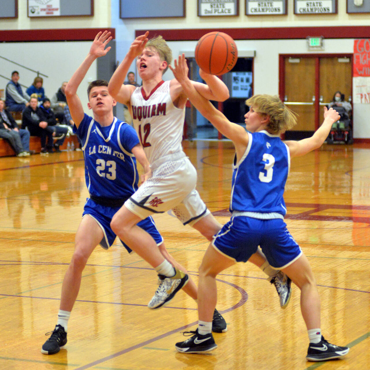 RYAN SPARKS | THE DAILY WORLD Hoquiam guard Michael Lorton Watkins passes the ball while defended by La Center’s Logan Rainey (23) and Garrett Maunu during the Grizzlies’ 86-57 victory in the 1A District 4 Tournament on Friday in Hoquiam.